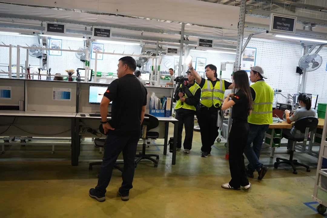 Mitarbeiter in Schutzausrüstung arbeiten an Maschinen in einer modernen Fertigungshalle