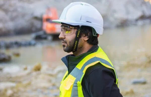 Bauarbeiter mit gelbem Schutzhelm als persönliche Schutzausrüstung auf einer Baustelle